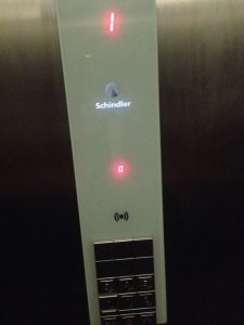 An image of the control panel in a lift, prominently featuring the word 'Schindler'